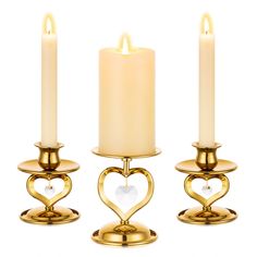 three gold candles with hearts on them and the candle holder is holding two white candles