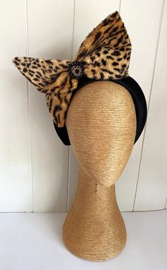 Animal Print Black Brown Bow Headband Fascinator This Animal Print Bowed Headband/Fascinator has been handmade from rayon faux fur & mounted on a hand-covered Black Velvet Headband with a Black/Gold Rhinestone pendant highlight in the center. The Bow itself has been lined with Tulle & slightly stiffened with fabric stiffener & hand-sewn into place giving it this showstopper appearance.  Would make a great Formal or Autumn Racing Day piece. All Pieces are Handmade "one-of-a-kind" Ooak and cannot Novelty Party Hair Accessories With Animal Ears, Party Headband With Ears, Novelty Party Hair Accessories With Ears, Novelty Cat Ears Hair Accessories For Parties, Party Novelty Cat Ears Hair Accessories, Novelty Party Hair Accessories With Cat Ears, Adjustable Cat Ears Headband For Parties, Fitted Cat Ears Costume Accessories For Party, Fitted Headband Costume Accessories For Party