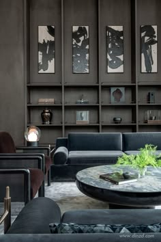 a living room filled with black furniture and lots of bookshelves on the wall