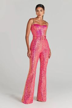 a woman in pink sequin jumpsuits posing for the camera with her hands on her hips