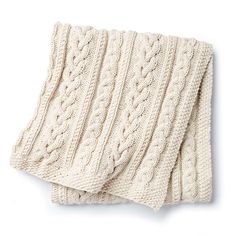 two white knitted blankets sitting on top of each other