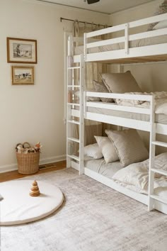 a room with bunk beds and pictures on the wall above them, in front of a carpeted floor