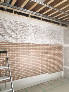 an unfinished room with a ladder and brick wall