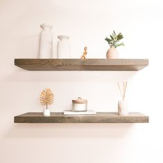 two wooden shelves with vases and candles on them