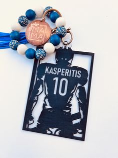 a keychain with a football player on it and some beaded balls around it