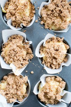 several muffins with crumbled topping sitting in a muffin tin