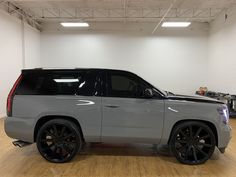 a silver truck parked in a garage with black rims on it's tires