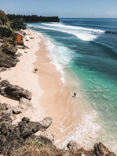 the beach is clear and blue with waves coming in from the water's edge