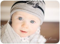 a baby with blue eyes wearing a hat