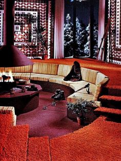 a person sitting on a couch in front of a fire place with red rugs