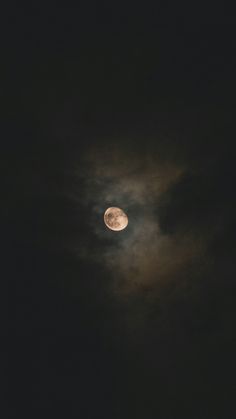 the moon is shining brightly in the dark night sky, with some clouds behind it