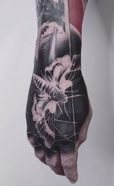 a person's hand with a tattoo on it and flowers in the middle of their arm