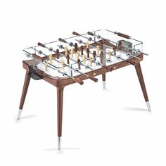 a wooden table topped with a glass top foosball and chess pieces in front of a white background