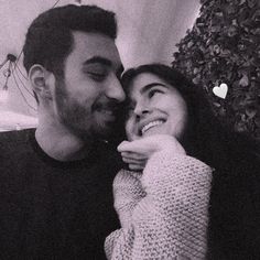 a man and woman smile at each other as they pose for a photo in black and white