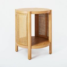 a wooden side table with an open basket on the top and one shelf in the middle