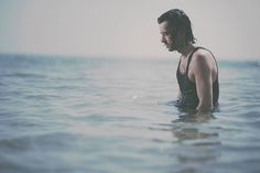 a woman standing in the ocean with her head above water