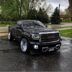 a black truck is parked in the rain