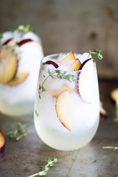 two glasses filled with ice and some fruit