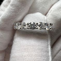 a three stone diamond ring sitting on top of a white cloth