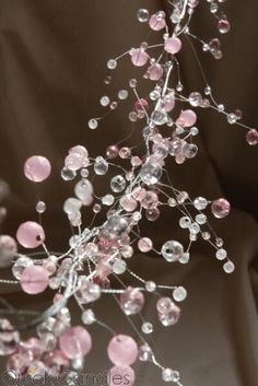 a close up of a tree made out of pink and silver beads on a black background