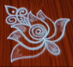 a wooden table topped with a drawing of a flower on top of it's surface