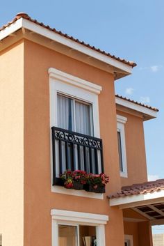 a house with a balcony and flower boxes on the balconies