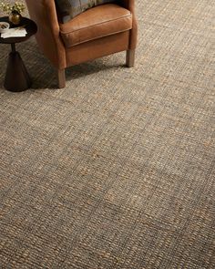 a brown chair sitting on top of a carpet covered floor