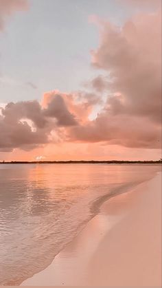 the sun is setting over the water at the beach