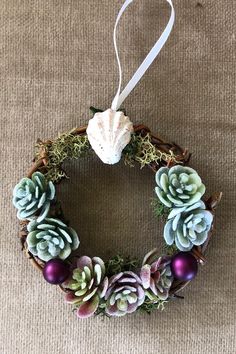 a wreath with succulents and eggs hanging on a wall