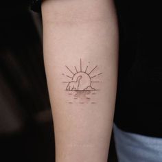 a tattoo on the arm of a woman with a bird and sun in the background