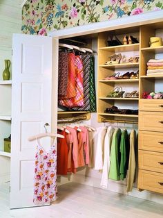 an open closet with clothes hanging on it