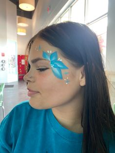 Near eye face painting of a flower Face Paint Birthday Party Ideas, Simple Flower Face Paint, Preppy Face Paint Ideas, Quick And Easy Face Painting For Kids, Super Easy Face Paint, Easy Face Painting For Beginners, Drawing On Face For Kids, Luau Face Painting Ideas