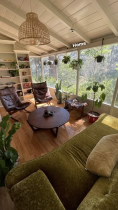 a living room filled with lots of furniture and plants on top of the windowsill