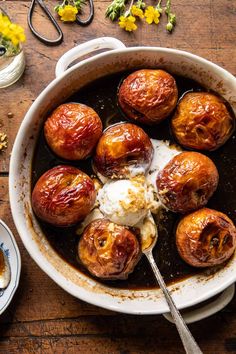 a pan filled with baked goods on top of a wooden table next to other dishes and utensils