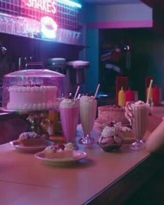 a woman sitting at a table with several desserts and drinks in front of her