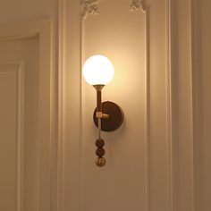 a wall mounted light on the side of a white door