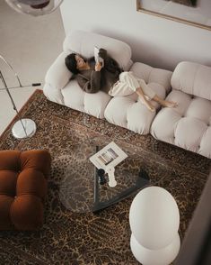 a woman laying on top of a couch in a living room