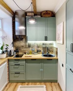 a kitchen with wooden floors and green cabinets