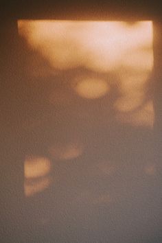 the shadow of a person's head on a wall with a light coming through it