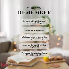 an open book sitting on top of a wooden table next to a christmas tree with lights in the background