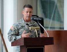 a man in uniform giving a speech at a podium