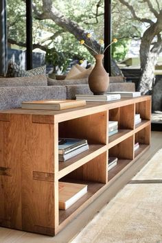 a living room with couches, bookshelves and a vase on the coffee table