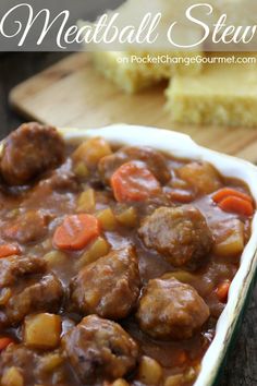 meatball stew in a white dish with carrots and gravy on the side