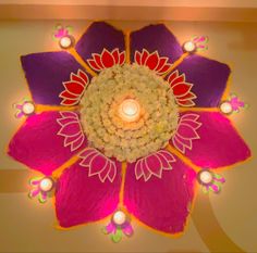 an overhead view of a decorated flower with lit candles in the center and on top