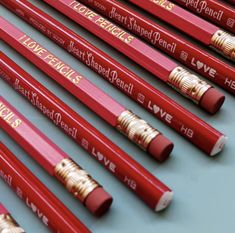 several red pencils with gold writing on them