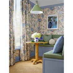 a living room with floral wallpaper and blue walls, along with a green bench