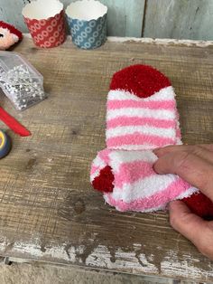 someone is decorating some cupcakes with red and white frosting