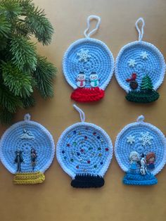 four crocheted ornaments hanging from a christmas tree ornament on a table