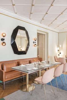 a dining room filled with lots of tables and chairs next to a wall mounted mirror