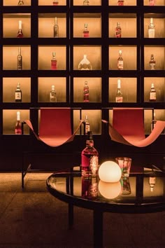 a glass table with bottles on the shelves behind it